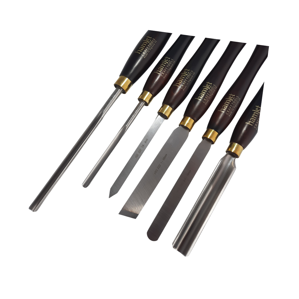 close up of a set of six woodturning chisels with high speed steel blades and wooden handles on a white background